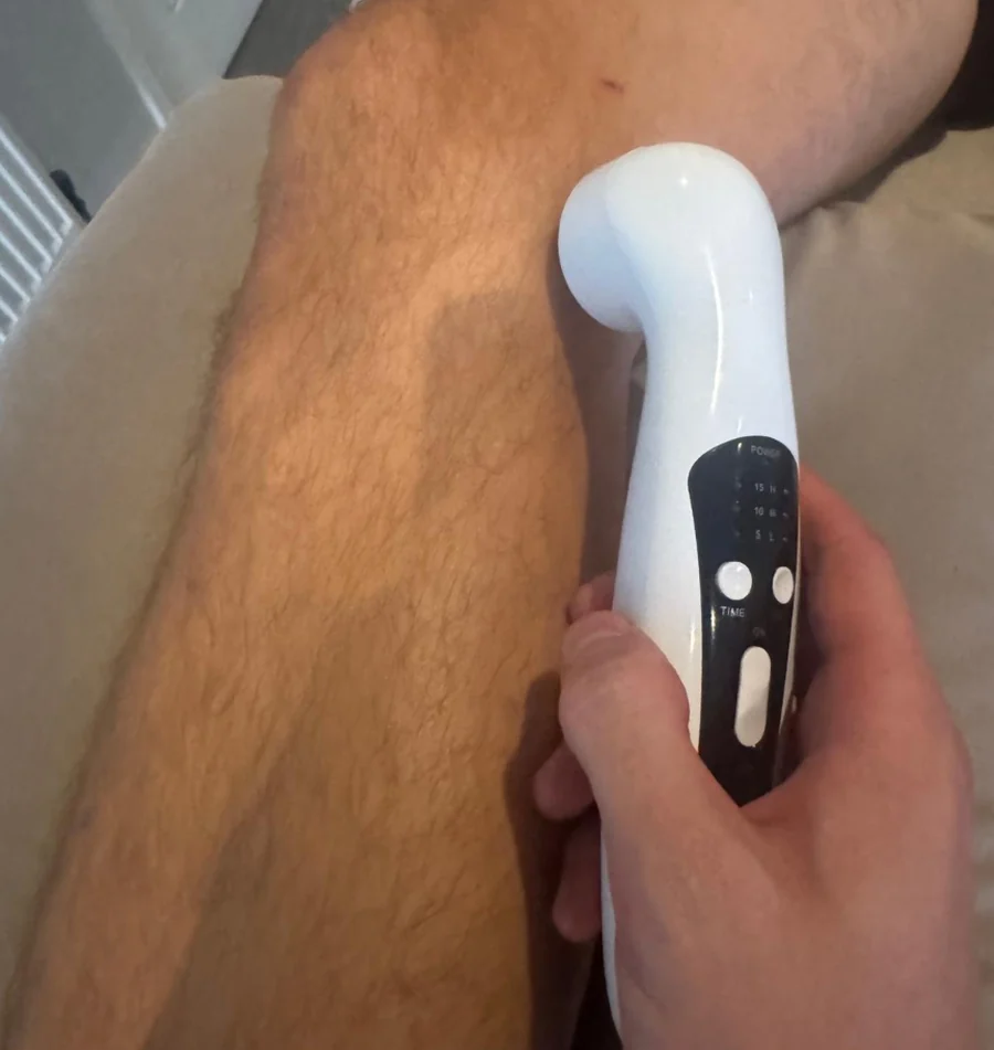 A handheld therapy device being used during a knee treatment